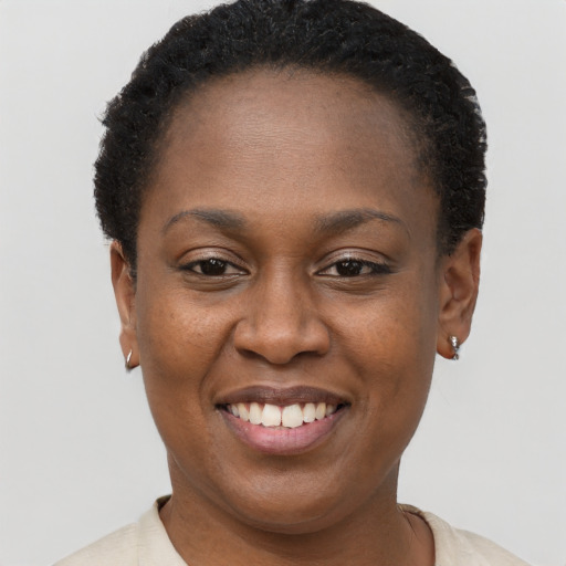 Joyful black young-adult female with short  brown hair and brown eyes