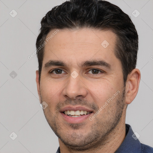 Joyful white young-adult male with short  black hair and brown eyes