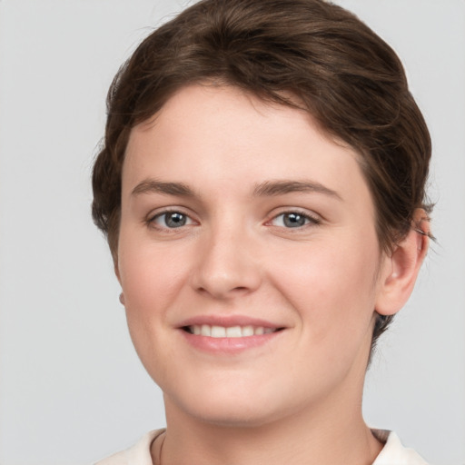 Joyful white young-adult female with short  brown hair and grey eyes