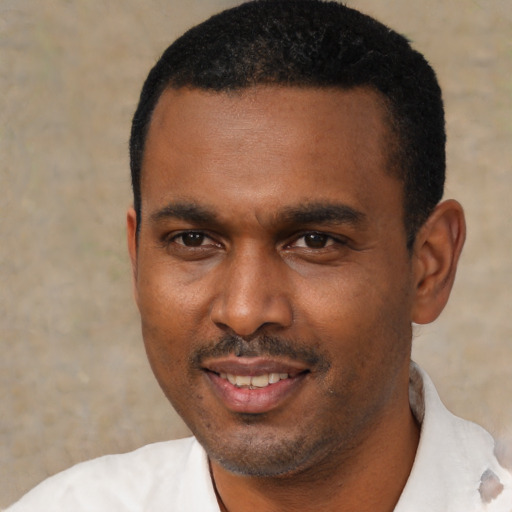 Joyful black young-adult male with short  black hair and brown eyes