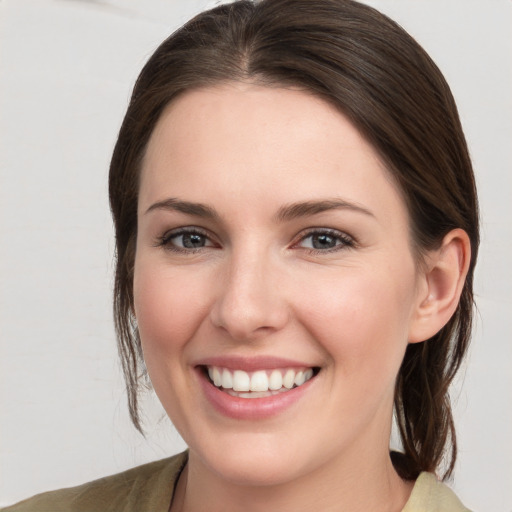 Joyful white young-adult female with medium  brown hair and grey eyes