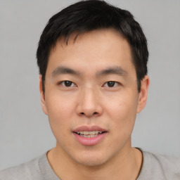 Joyful asian young-adult male with short  black hair and brown eyes