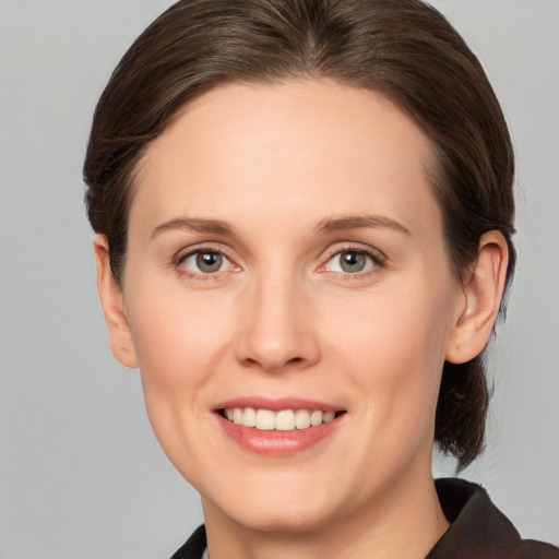 Joyful white young-adult female with medium  brown hair and grey eyes