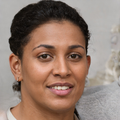 Joyful latino young-adult female with short  brown hair and brown eyes