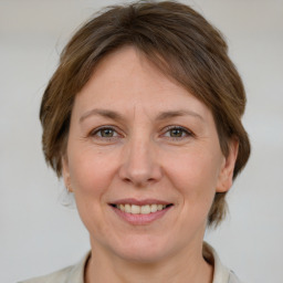 Joyful white adult female with medium  brown hair and grey eyes