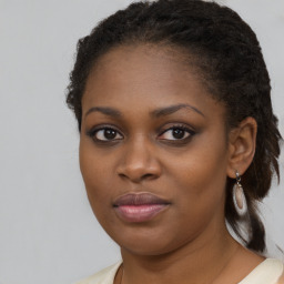 Joyful black young-adult female with medium  brown hair and brown eyes