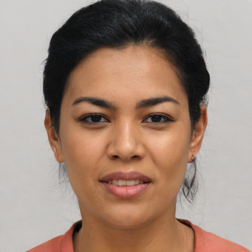 Joyful latino young-adult female with short  black hair and brown eyes