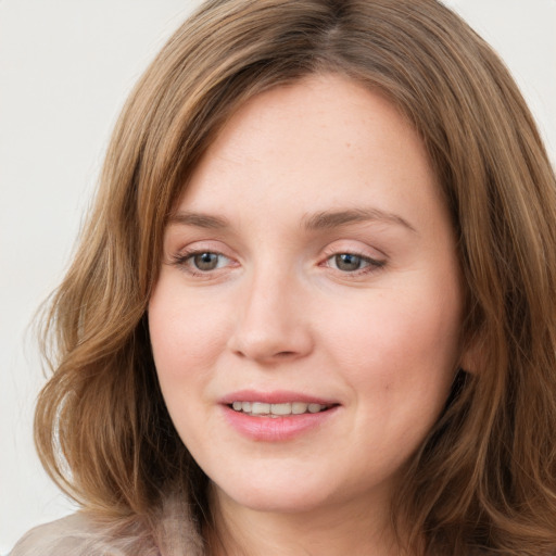 Joyful white young-adult female with long  brown hair and green eyes