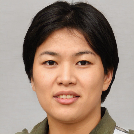 Joyful asian young-adult female with short  brown hair and brown eyes