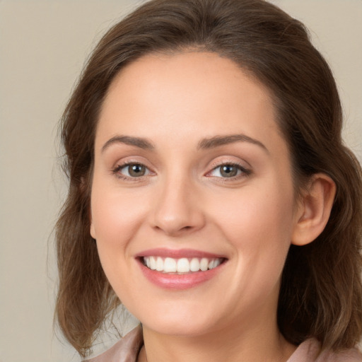 Joyful white young-adult female with long  brown hair and green eyes