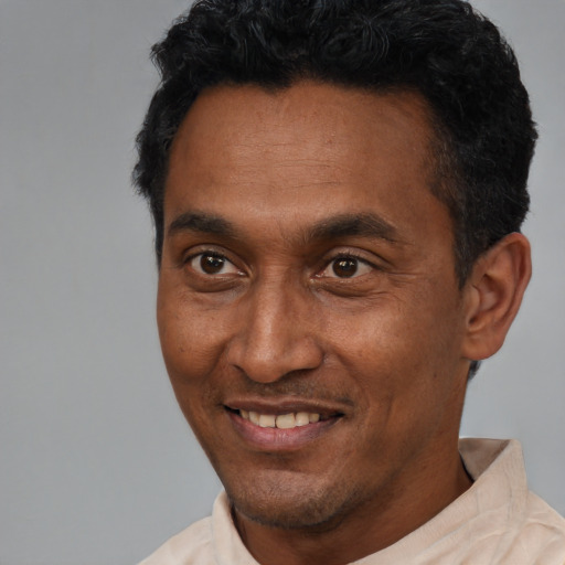 Joyful latino adult male with short  black hair and brown eyes