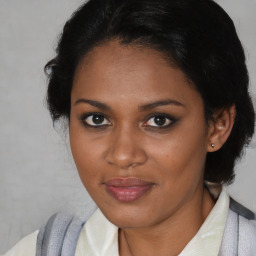 Joyful black young-adult female with medium  brown hair and brown eyes