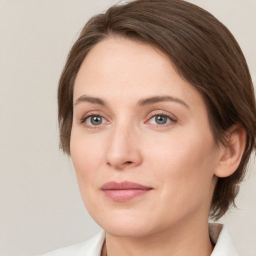 Joyful white young-adult female with medium  brown hair and green eyes