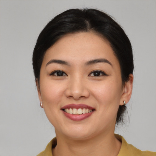 Joyful asian young-adult female with medium  brown hair and brown eyes
