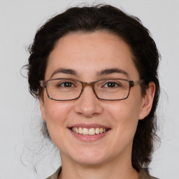 Joyful white adult female with medium  brown hair and brown eyes