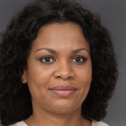 Joyful black adult female with long  brown hair and brown eyes