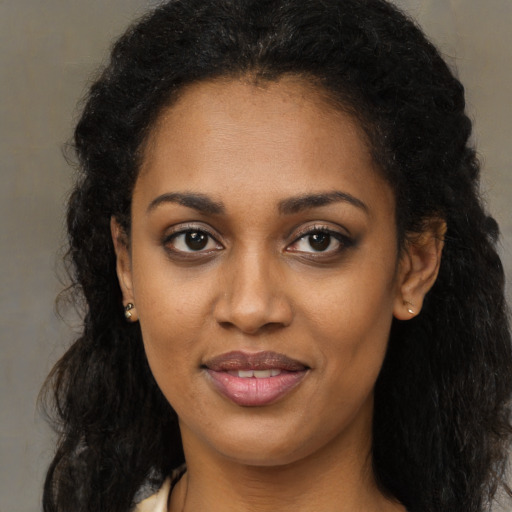 Joyful black young-adult female with long  brown hair and brown eyes