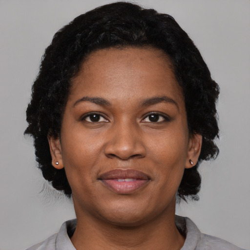 Joyful black young-adult female with short  black hair and brown eyes