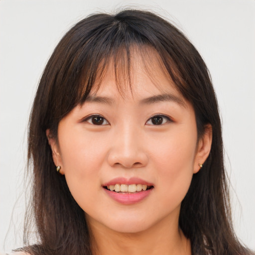 Joyful asian young-adult female with long  brown hair and brown eyes