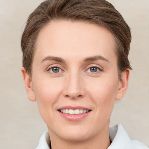 Joyful white young-adult female with short  brown hair and grey eyes