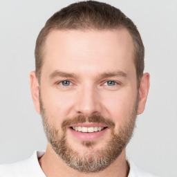 Joyful white young-adult male with short  brown hair and grey eyes