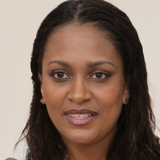 Joyful black young-adult female with long  brown hair and brown eyes