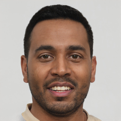 Joyful black young-adult male with short  black hair and brown eyes