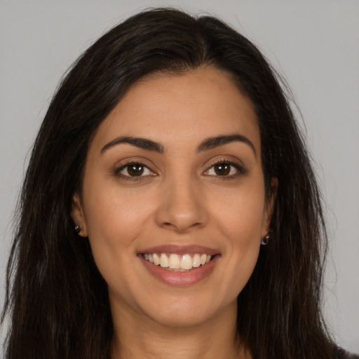 Joyful latino young-adult female with long  brown hair and brown eyes