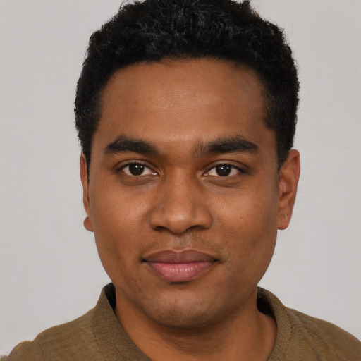 Joyful black young-adult male with short  black hair and brown eyes