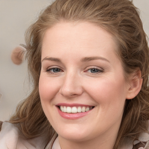 Joyful white young-adult female with long  brown hair and blue eyes