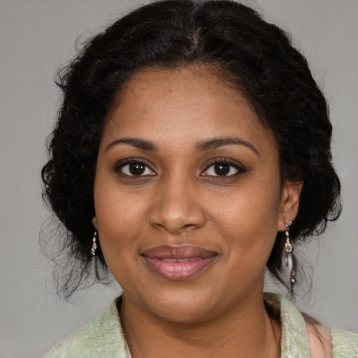 Joyful black young-adult female with medium  brown hair and brown eyes