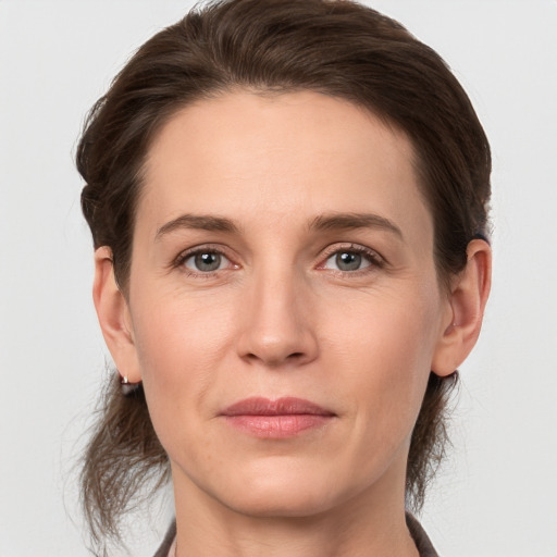 Joyful white adult female with medium  brown hair and grey eyes