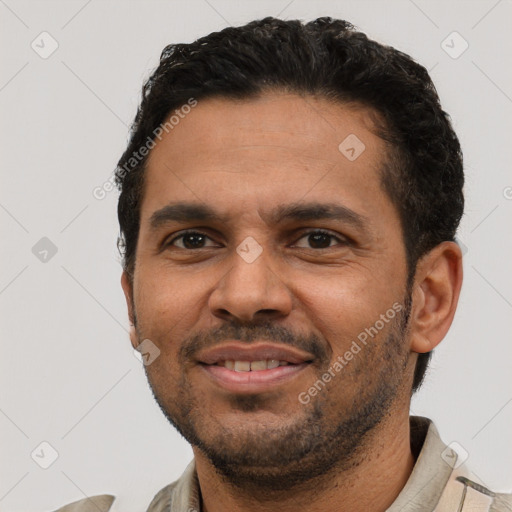 Joyful latino young-adult male with short  black hair and brown eyes