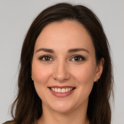 Joyful white young-adult female with long  brown hair and brown eyes