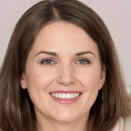 Joyful white young-adult female with long  brown hair and brown eyes