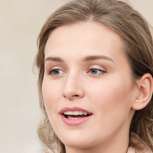 Joyful white young-adult female with long  brown hair and blue eyes