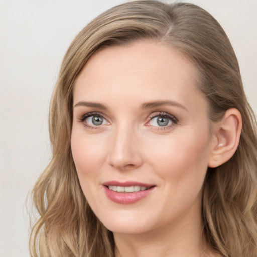 Joyful white young-adult female with long  brown hair and blue eyes