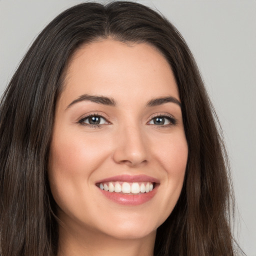 Joyful white young-adult female with long  brown hair and brown eyes