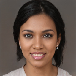 Joyful black young-adult female with medium  brown hair and brown eyes