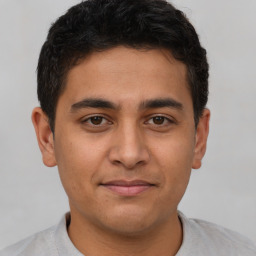 Joyful latino young-adult male with short  brown hair and brown eyes
