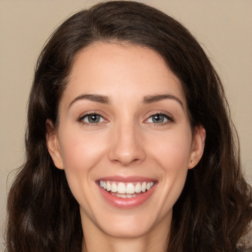 Joyful white young-adult female with long  brown hair and brown eyes