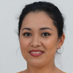 Joyful latino young-adult female with long  brown hair and brown eyes