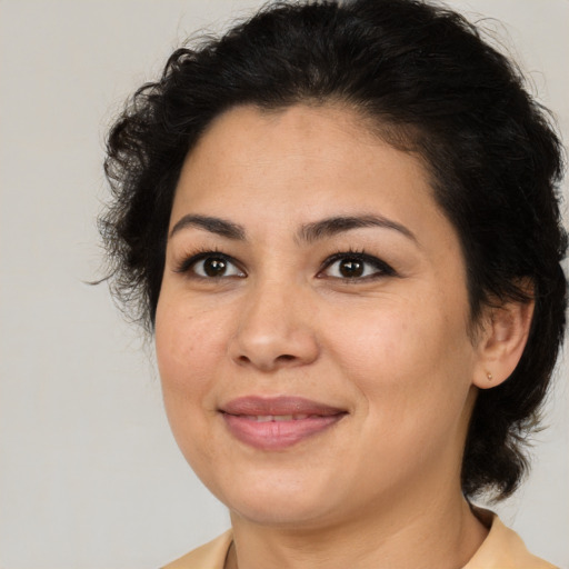 Joyful latino adult female with medium  brown hair and brown eyes