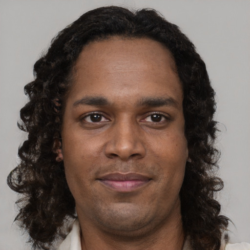 Joyful black young-adult male with short  brown hair and brown eyes