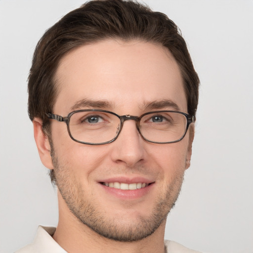 Joyful white young-adult male with short  brown hair and grey eyes