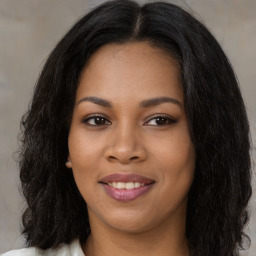 Joyful black young-adult female with long  brown hair and brown eyes