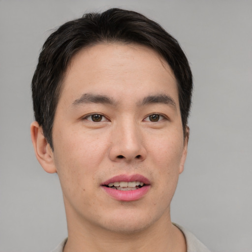 Joyful asian young-adult male with short  brown hair and brown eyes