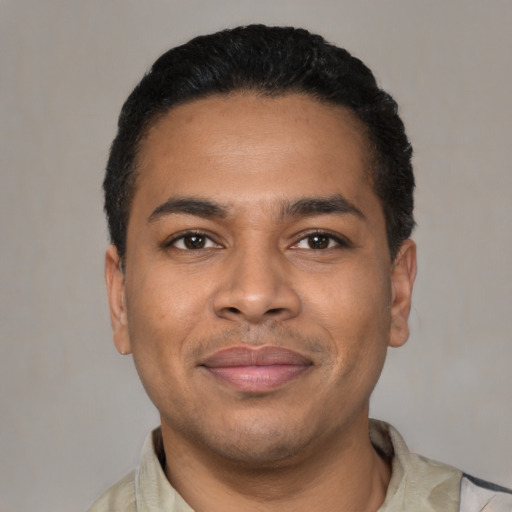 Joyful latino young-adult male with short  black hair and brown eyes