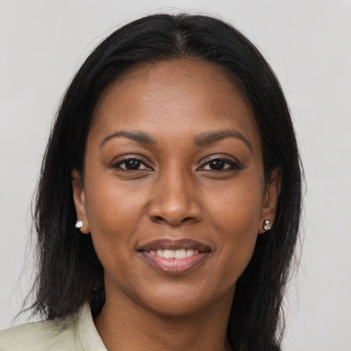 Joyful black young-adult female with long  black hair and brown eyes