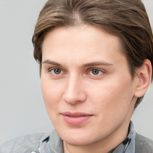 Joyful white young-adult female with short  brown hair and grey eyes